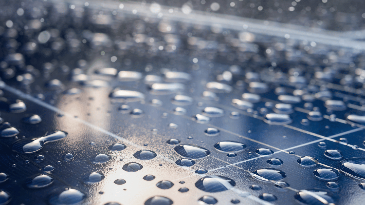 close-up of rain droplets on a solar panel, highlighting the natural cleaning effect of heavy rain on solar panels and maintaining their efficiency