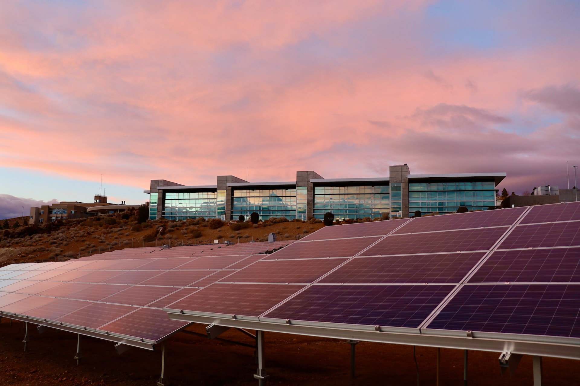 solar panels in orange county in front of large building at sunset